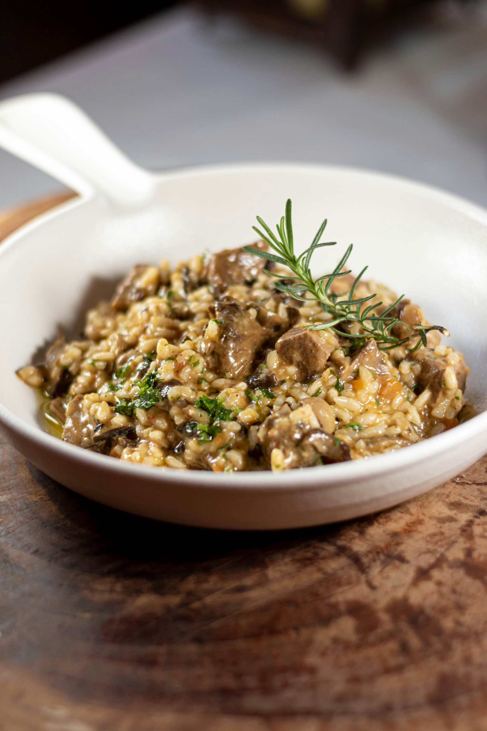 a white bowl filled with food on top of a wooden table